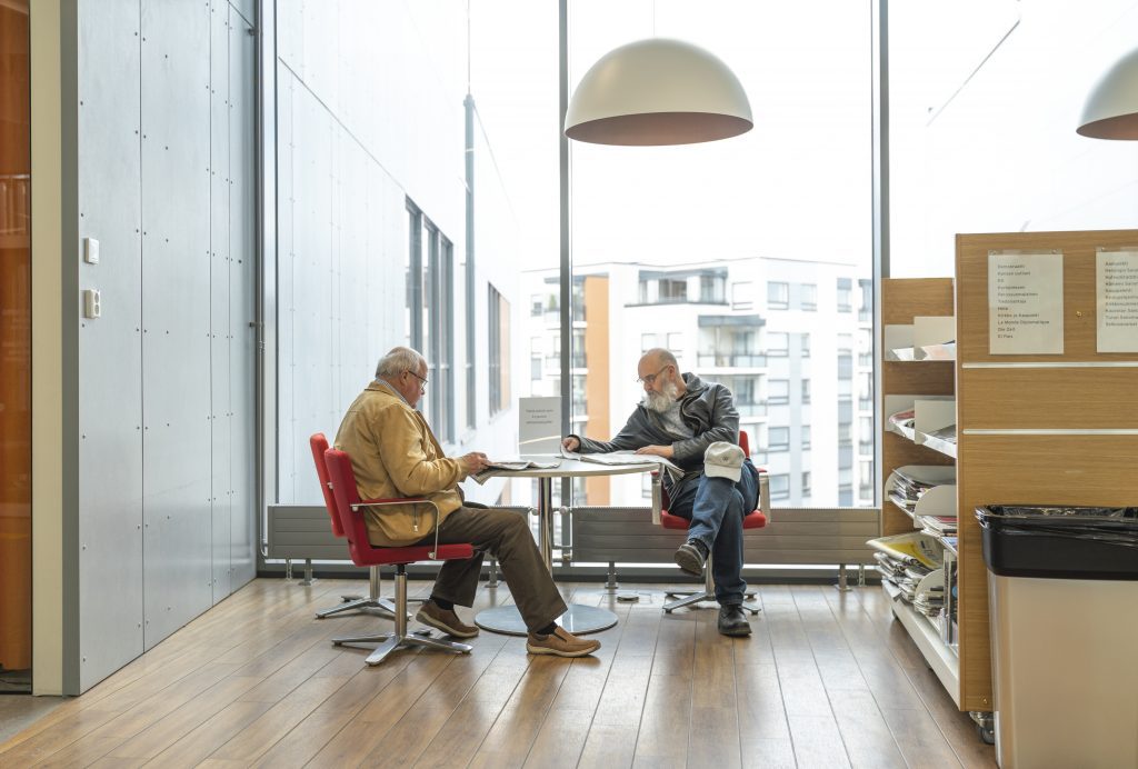 Old men reading papers in library